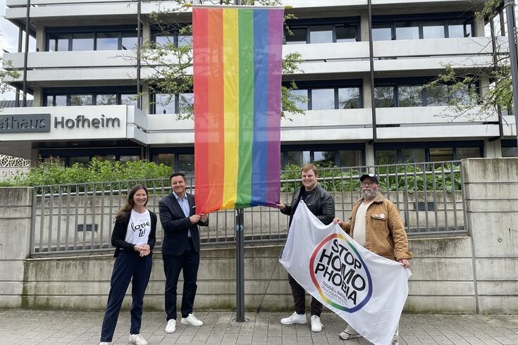Carmen Weber aus dem Rathaus, Bürgermeister Christian Vogt, Sven Rühl und Hermann von „Colorful e.V. vor der Regenbogenfahne am Rathaus 