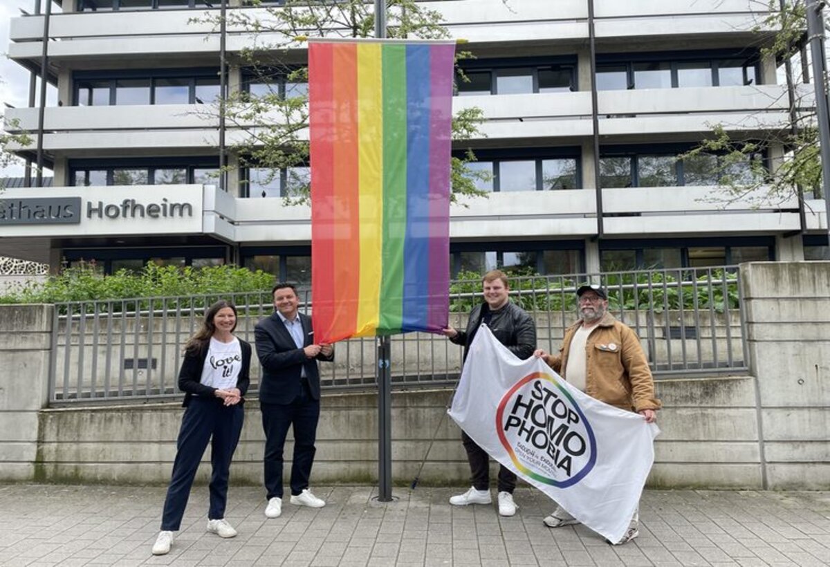 Carmen Weber aus dem Rathaus, Bürgermeister Christian Vogt, Sven Rühl und Hermann von „Colorful e.V. vor der Regenbogenfahne am Rathaus 