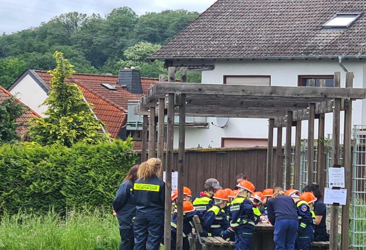 Betreuerinnen und Betreuer der Kinderflamme 2024 in Wildsachsen mit teilnehmenden Kindern am Tisch versammelt bei der Arbeit 