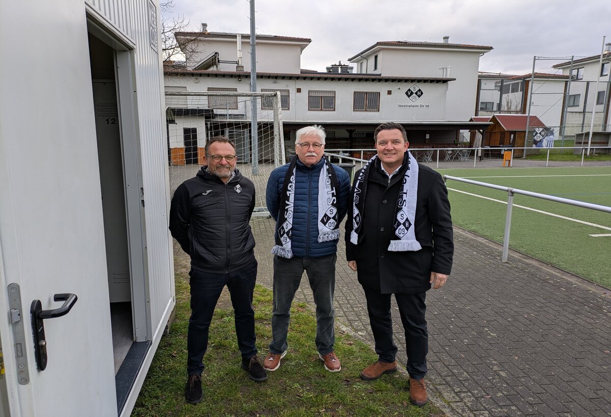 Stellvertretender Vorsitzender SV 09 Hofheim Andreas Marx, SV 09-Ältestenratsvorsitzender Ulrich Beßmann und Bürgermeister Christian Vogt vor den Containern.