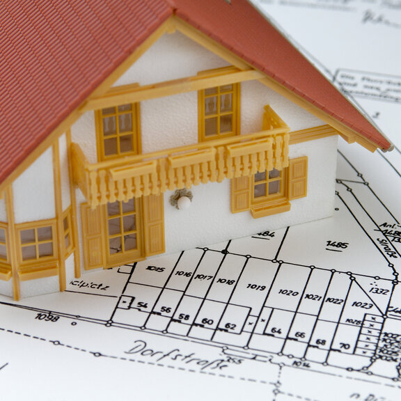 Miniaturhaus steht auf einem Lageplan