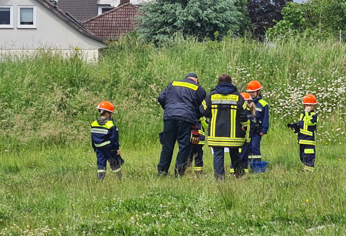 Betreuerinnen und Betreuer der Kinderflamme 2024 in Wildsachsen mit teilnehmenden Kindern auf einer Wiese